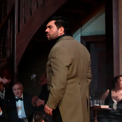 Luis turning his head toward the audience in an elegant Carmen performance scene.